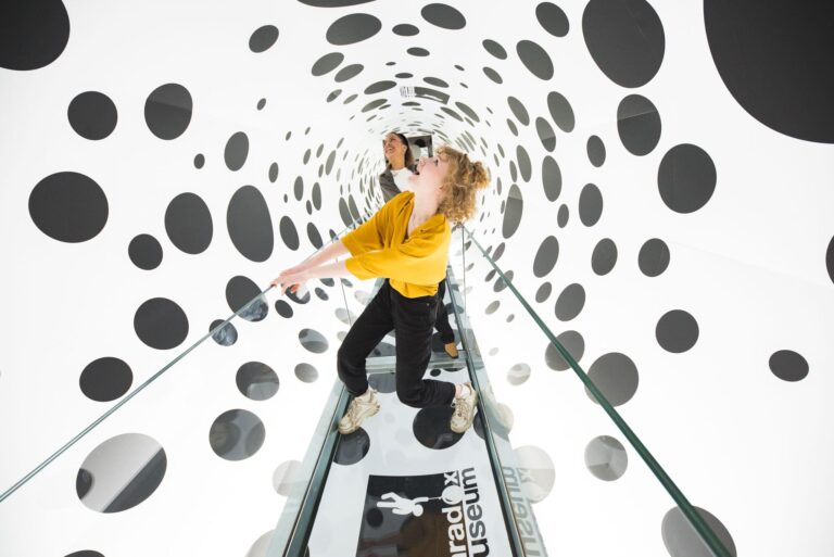 Two individuals in illusion exhibit at Paradox Museum Las Vegas.